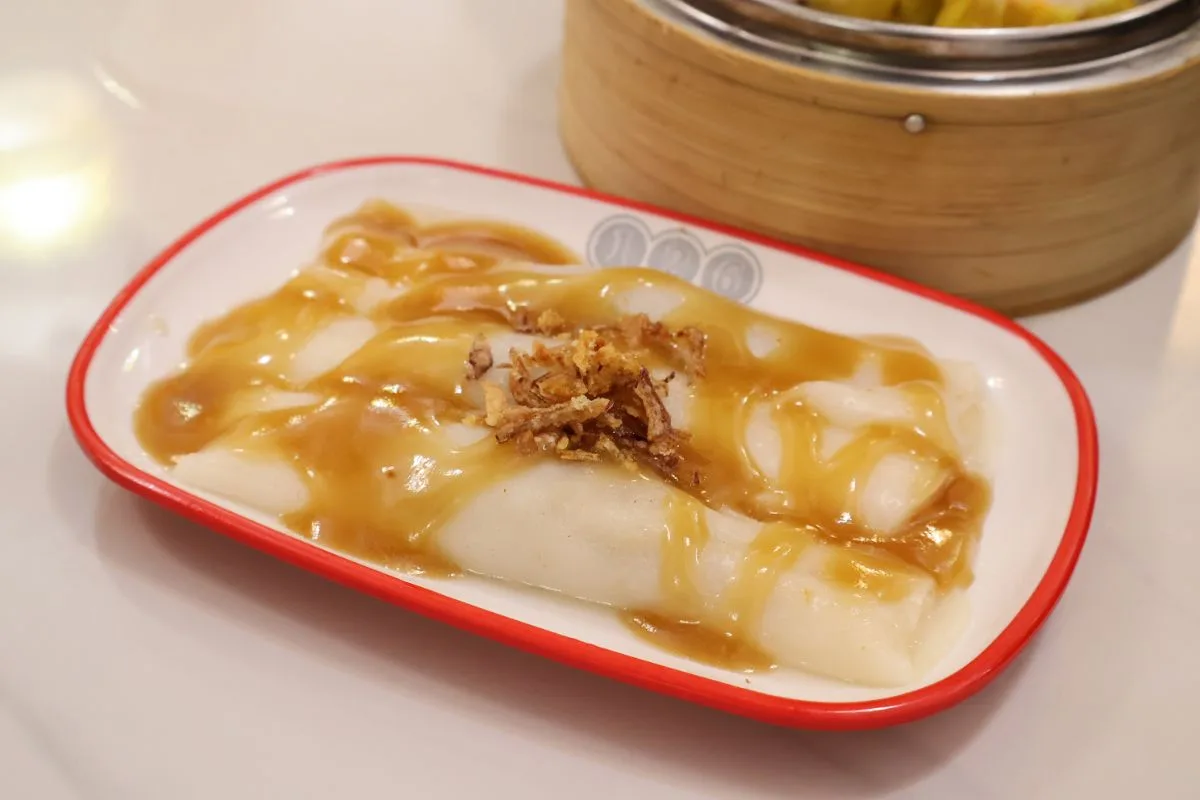 A plated rice roll from 126 Dim Sum, sauced and topped with fried shallots