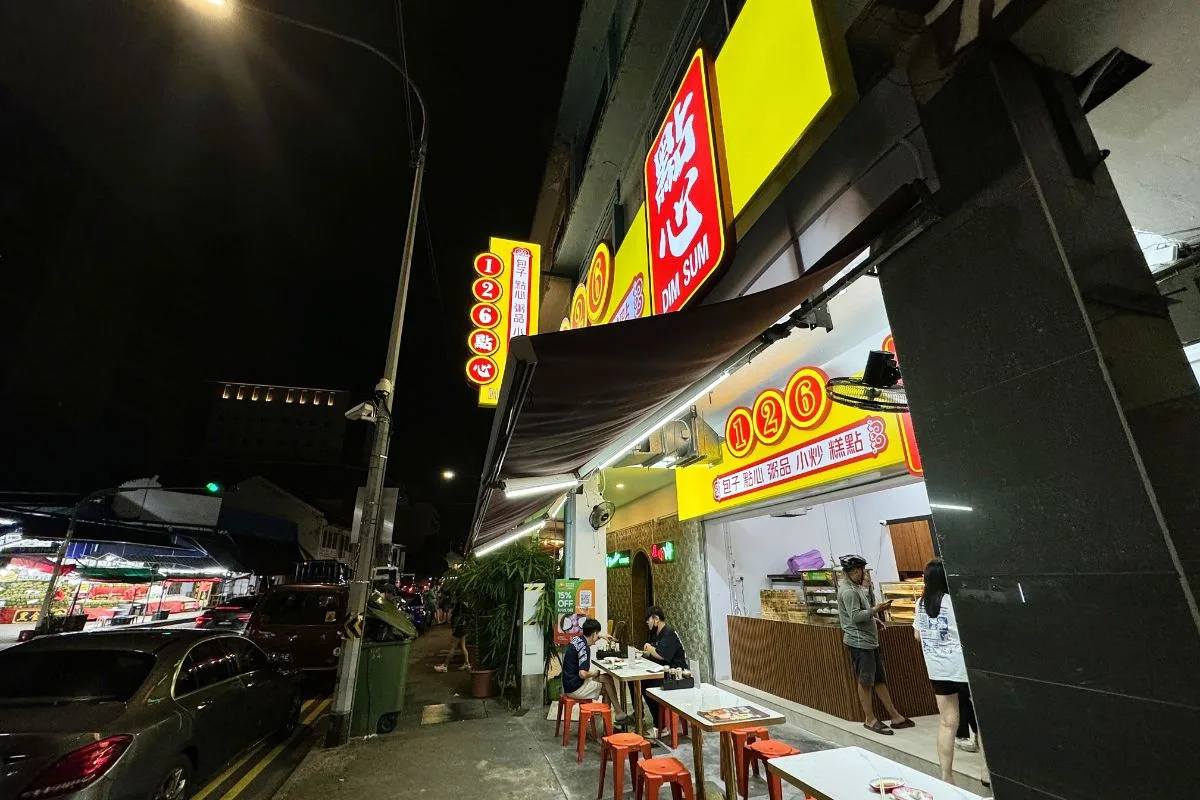 126 Dim Sum at 126 Sims Avenue after dark, the yellow 126 signboard lit and tables set out on the five-foot way